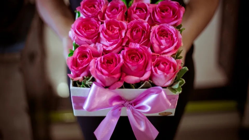 Cadeaudoos vol roze rozen met een strik errond
